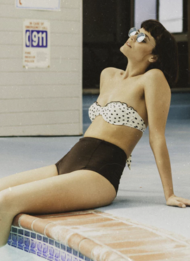 Woman in bikini lounging poolside